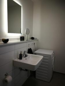 Baño blanco con lavabo y espejo en Komfort-Wohnung 03 FehmarnBrise, en Burg auf Fehmarn