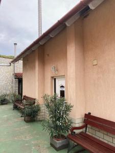 a building with benches and plants in front of it at Bor-Bazilika-Vendégház in Tarcal