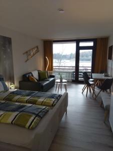 ein Schlafzimmer mit einem Bett und ein Wohnzimmer in der Unterkunft See Harmonie Haus 4 Jahreszeiten in Hahnenklee-Bockswiese