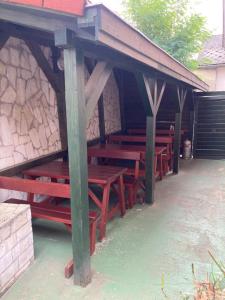 a group of wooden picnic tables in a building at Bor-Bazilika-Vendégház in Tarcal