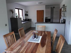 a kitchen and dining room with a wooden table and chairs at Ferienhaus Biernat in Prinzenmoor