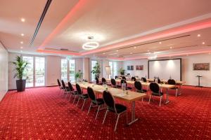 a conference room with tables and chairs and a projection screen at Edelfinger Hof in Bad Mergentheim