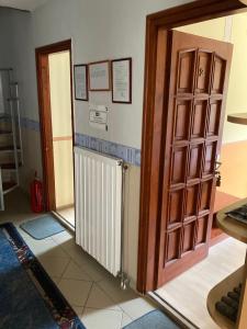 Habitación con puerta abierta y radiador en Bor-Bazilika-Vendégház en Tarcal