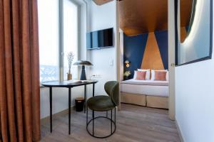 Cette chambre comprend un lit, une table et une chaise. dans l'établissement Hotel Sacha, à Paris