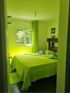 Un pat sau paturi într-o cameră la Bungalow charmant à Le Moule avec piscine et jardin