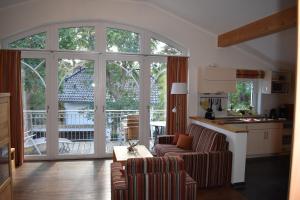 ein Wohnzimmer mit 2 Stühlen und einem Tisch sowie eine Küche in der Unterkunft Villa Carina "Carina's 921" in Baabe