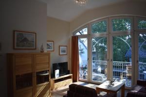 a living room with a large sliding glass door at Villa Carina "Carina's 921" in Baabe