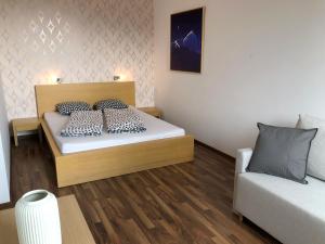 1 dormitorio pequeño con 1 cama y 1 sofá en Štrbské Pleso Apartmán Oliver #40 en Štrbské Pleso