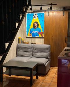 una sala de estar con sofá y una foto de un balón de fútbol en Bed&Art, en Nápoles