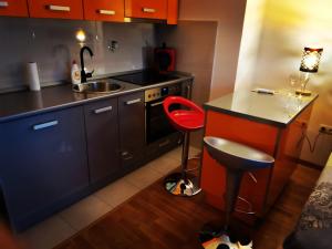 cocina con fogones y taburete rojo en Apartment CITY, en Doboj