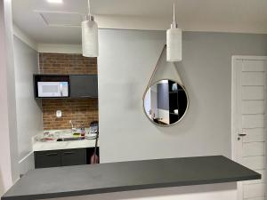 a kitchen with a sink and a mirror on the wall at Apartamento Studio Centro de Macapá in Macapá