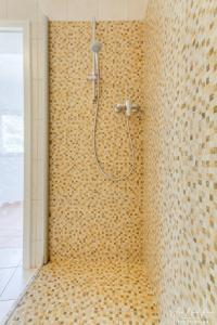 y baño con ducha y pared de azulejos. en Sobre de Granadella Haus 5, en Jávea