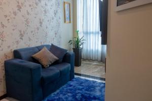 a living room with a blue chair and a blue rug at Apart vitória in Feira de Santana