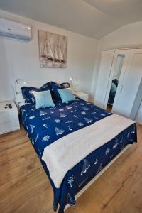 a bedroom with a bed with a blue comforter at Vila Punta in Stomorska