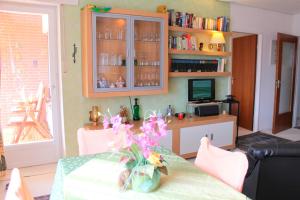 ein Wohnzimmer mit einem Tisch und einer Blumenvase in der Unterkunft Haus Strandfee - App 12 in Grömitz