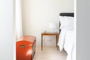 a bedroom with a bed and a table with a lamp at Stylish new 1br apt in Aurinkolahti in Helsinki