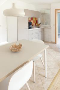 a white kitchen with a white table and chairs at Kolja in Zingst