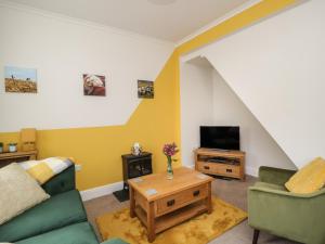 a living room with a couch and a tv at Herdwick Heaf in Cleator