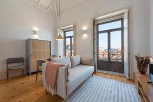 ein Wohnzimmer mit Couch und Balkon in der Unterkunft Tripas Coração Taipas Historical Center in Porto