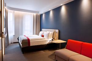 een hotelkamer met een bed en een bank bij Holiday Inn Express - Mülheim - Ruhr, an IHG Hotel in Mülheim an der Ruhr