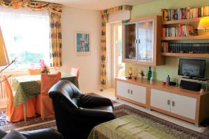 ein Wohnzimmer mit einem Sofa und einem TV in der Unterkunft Haus Strandfee - App 12 in Grömitz
