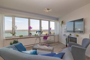 a living room with a couch and a large window at Traumblick! Mitten im Wasser u. doch ganz oben:) in Schleswig