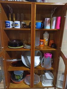 a wooden shelf with plates and dishes on it at Casa com churrasqueira wi-fi, Tv com Netflix e YouTube in Balneário Gaivotas
