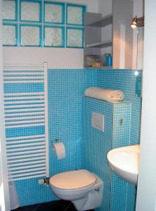 a blue tiled bathroom with a toilet and a sink at Ferienhaus Bergstädt "Utspann" in Westerbergen