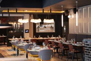 a dining room with tables and chairs and lights at Malmaison York in York
