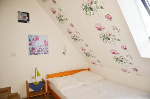 a bedroom with a bed with flowers on the wall at Ferienhof Frohne - Spielzimmer in Merzen