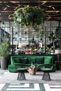 een groene bank in een kamer met potplanten bij Hotel Skt Petri in Kopenhagen