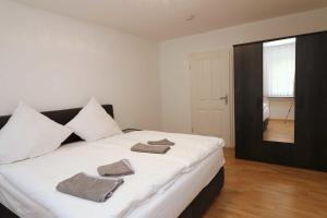 1 dormitorio con 1 cama grande y toallas. en Aparthotel Kompass A 304, en Essen