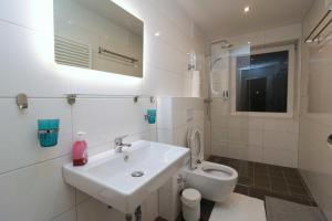 a white bathroom with a sink and a toilet at Aparthotel Kompass A 304 in Essen