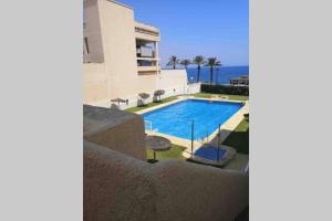 ein Pool vor einem Haus mit dem Meer in der Unterkunft Sea Level, Apto sofisticado en primera linea playa in Aguadulce