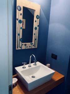 bagno con lavandino bianco e specchio di Casa Las Margaritas a San Carlos de Bariloche