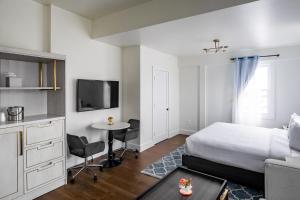 1 dormitorio con cama, mesa y TV en Scarborough Inn, en Ocean City