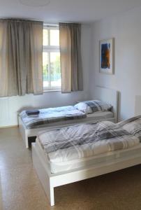 two beds sitting in a room with a window at Haus Roy - Ferienwohnung Erdgeschoß in Zülpich