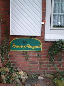 ein Schild an der Seite eines Backsteinhauses in der Unterkunft Haus "Asgard" in Brinjahe