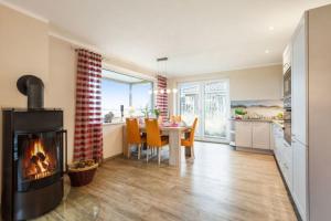 a kitchen and dining room with a fireplace in a living room at Wellness - Bungalow Strandgut in Klausdorf