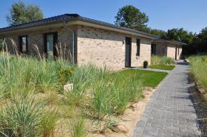 a brick house with a pathway in front of it at Wellness - Bungalow Strandgut in Klausdorf