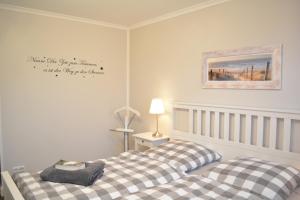 a bedroom with two beds and a picture on the wall at Ostwind in Börgerende-Rethwisch