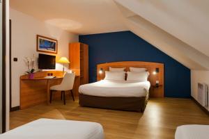 a hotel room with a bed and a desk at Comfort Hotel Evreux in Évreux