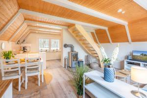 a living room with wooden ceilings and a table and chairs at Luett Anna Ferienhaus auf Usedom in Quilitz