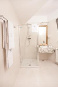 La salle de bains blanche est pourvue d'une douche et d'un lavabo. dans l'établissement Villa Boutique Lafayette, à Bucarest