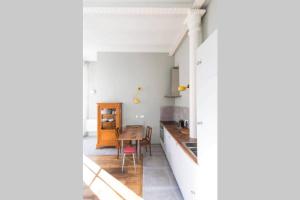 a kitchen with a table and a dining room at La Chassagne, en plein cœur de ville in Dijon