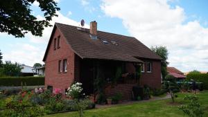 uma pequena casa de tijolos vermelhos com telhado em Pension Limone Ferienwohnung 2 em Neu Lindenberg