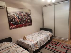 two beds in a room with a painting on the wall at Уютен апартамент в централната част на Стара Загора in Stara Zagora