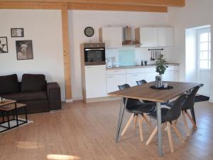 ハイデにあるSkandinavische Ferienwohnung auf Gut Bennewohld JHのキッチン、リビングルーム(テーブル、椅子付)