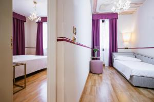 ヴェネツィアにあるホテル ド ポッツィのベッド2台とソファが備わるホテルルームです。