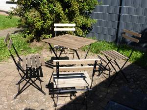 a wooden table and two chairs and a picnic table and chairs at Zum Roemernest in Würzberg